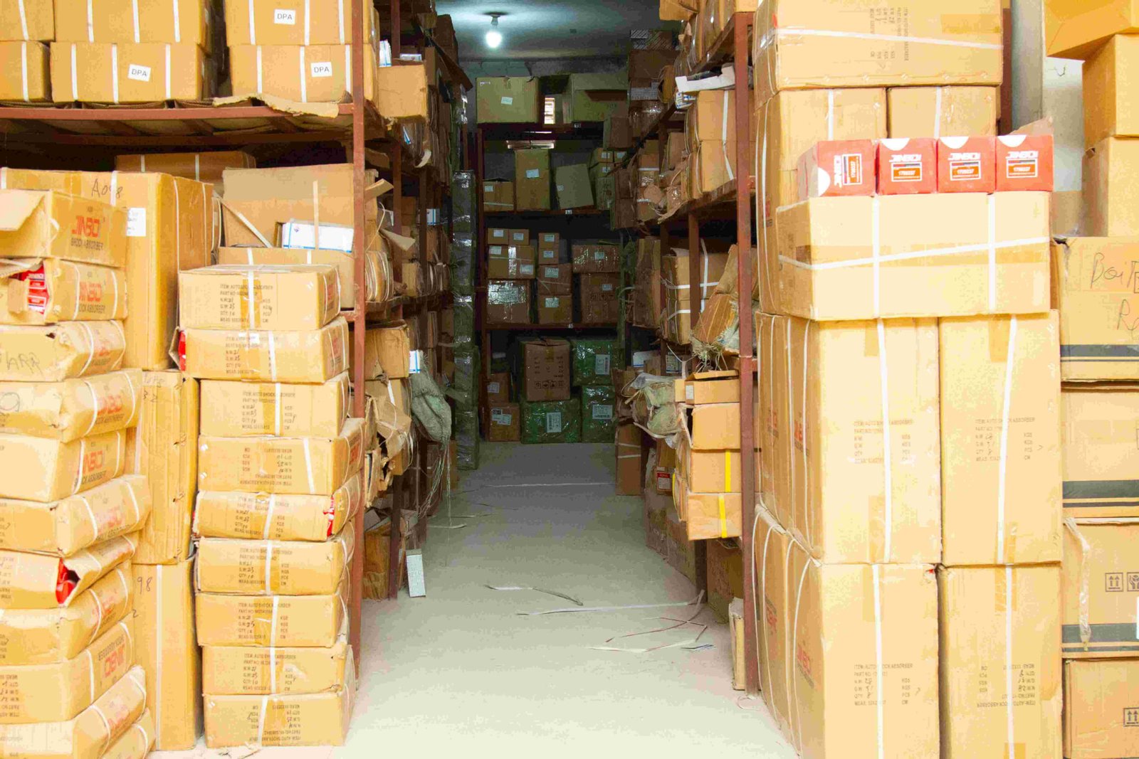 Allée de l'entrepôt remplie de cartons d'amortisseurs